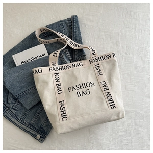 Vue détaillée d'un sac cabas en toile crème avec impression noire FASHION BAG