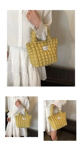 Detail of yellow popcorn textured tote bag with LOVE FASHION label and pleated fabric style