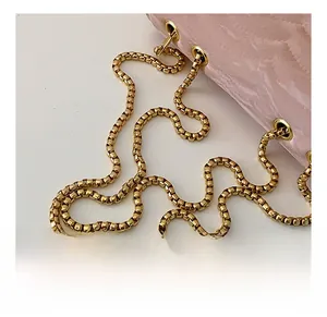 Detail of premium golden metal chain strap with a pink marble texture square bag