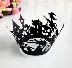 Macro detail of laser-cut Halloween cupcake wrapper with witch and castle silhouette