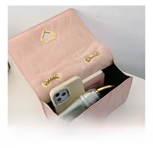 Detail showing internal capacity of the pink chain bag for phone and makeup