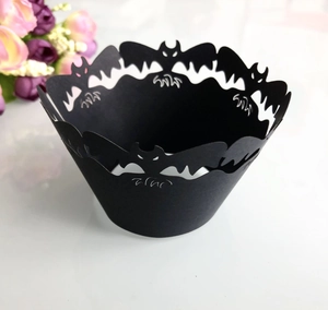 Intricate laser-cut black Halloween cupcake wrapper with hollow bat design detail