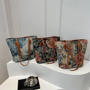 Three vintage floral jacquard tote bags with leather straps on a white pedestal