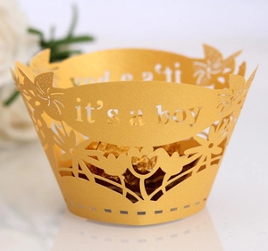 Detailed laser-cut gold cupcake wrapper with 'it's a boy' text for baby shower decor