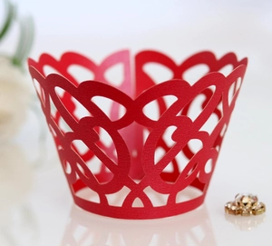 Macro view of red laser-cut cupcake wrapper with intricate heart and spiral pattern