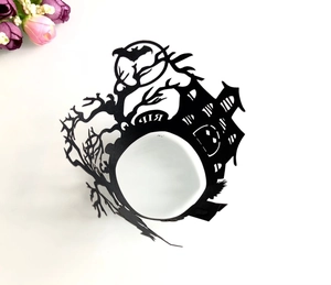 Laser-cut Halloween cupcake wrapper with black castle, bats, and pumpkin silhouettes