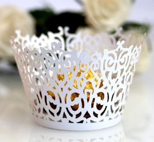 Close-up of white laser-cut lace cupcake wrapper with elegant floral hollow design