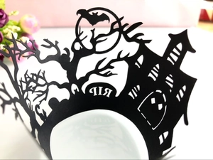 Macro detail of Halloween cupcake liners with haunted house, RIP tombstone, and bat motifs