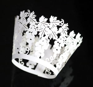 Detailed laser-cut white vine and grape pattern wrapper for elegant cake decoration