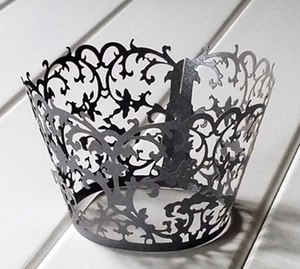 Detailed laser-cut vine patterns on black cupcake wrappers for dessert table decoration