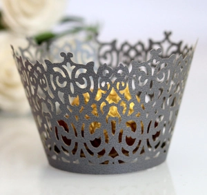 Detail of silver laser-cut cupcake wrapper with floral pattern and gold chocolate