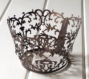 Detail of vintage laser-cut filigree pattern on brown cupcake wrapper with buckle