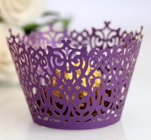 Macro detail of laser-cut purple cupcake wrapper with intricate lace pattern and chocolate