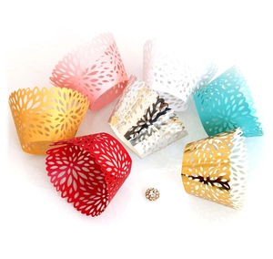 Laser cut lace cupcake wrappers in multiple metallic colors with floral patterns for wedding