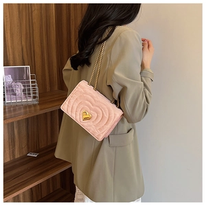 Detailed view of pink quilted heart-shaped pattern and golden heart-lock on small bag