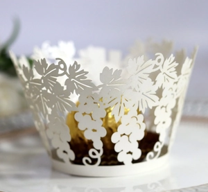Macro detail of laser-cut grape vine pattern on ivory white cupcake wrapper