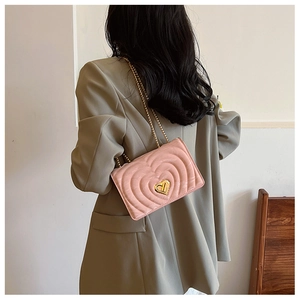 Pink heart-shaped crossbody bag with gold chain strap and quilted lock detail
