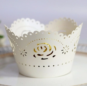 Detail of laser-cut ivory white rose cupcake wrapper showing intricate floral patterns