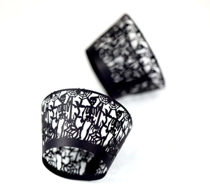 Laser-cut black Halloween cupcake wrappers with skull and spider web hollow designs