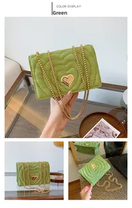 Detail view of avocado green crossbody bag with heart quilting and gold lock
