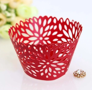 Detailed laser-cut hollow floral pattern on a red paper cupcake liner for weddings