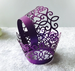 Detail of laser-cut cupcake wrapper in lavender purple with heart and vine lace patterns