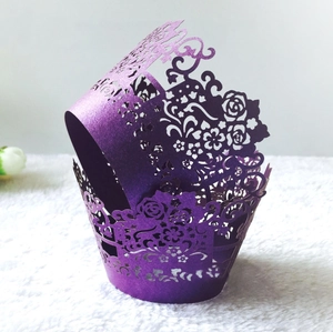 Detail of laser-cut purple cupcake wrappers with elegant rose patterns and pearl finish