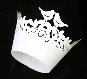 Elegant white laser-cut cupcake wrappers with bird and leaf patterns for weddings
