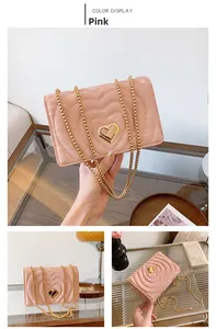 Pink heart-quilted crossbody bag with gold chain strap and metal heart lock detail