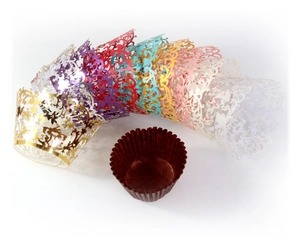 Close-up of laser-cut cupcake wrappers with elegant vine patterns in multiple metallic colors