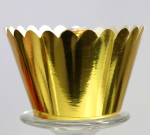 Close-up of golden metallic cupcake wrapper with wavy edges and mirror finish