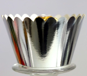Macro detail of a metallic silver wavy edge cupcake liner with a golden chocolate inside