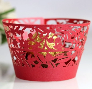 Detailed laser-cut vine patterns on red festive cupcake wrappers for party decoration