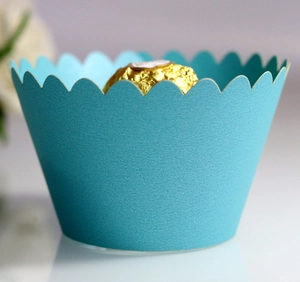 Close-up of laser-cut light blue cupcake wrapper with elegant wavy edges and matte texture