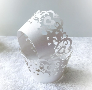 Laser cut white paper cupcake wrappers with elegant heart lace design for wedding party