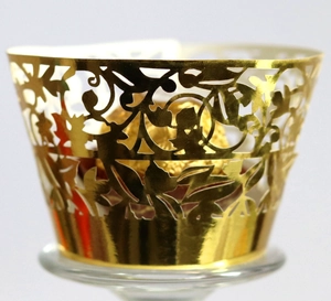 Detailed laser-cut hollow floral design on golden metallic cupcake wrappers for party decor