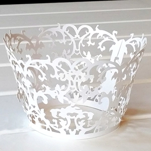 White laser cut cupcake wrappers with classical filigree pattern for wedding decorations