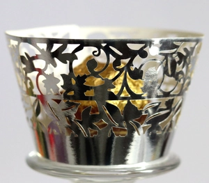 Elegant silver laser-cut cupcake wrappers with intricate vine pattern for wedding decor