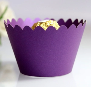 Detail of purple wavy paper cupcake wrapper with a chocolate inside for party decoration
