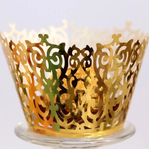 Elegant gold hollow cupcake wrapper with laser-cut vine patterns for wedding decoration