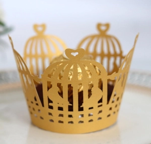 Macro shot of gold laser-cut cupcake wrapper with crown and heart design details