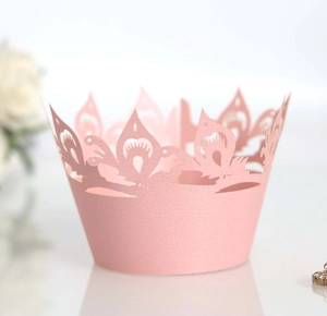 Detailed laser-cut crown pattern on light pink cupcake wrapper for wedding party decor