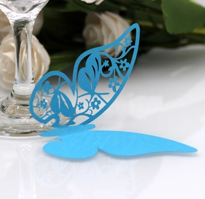 Macro detail of laser-cut butterfly place cards in royal blue for wedding wine glasses