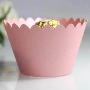 Elegant pink laser-cut cupcake wrappers with wavy scalloped edges for wedding party decor