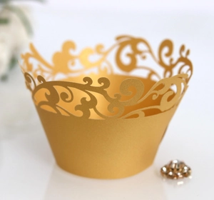 Detail of laser-cut gold cupcake wrapper with vintage filigree vine pattern