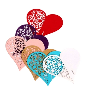 Laser cut heart place cards with intricate flower patterns in various colors for weddings