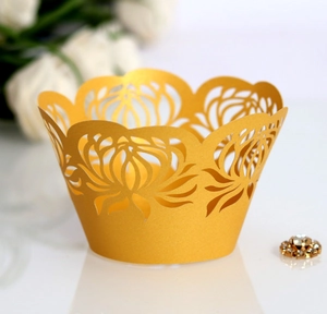 Detailed laser-cut gold floral cupcake wrapper with intricate vine patterns for weddings