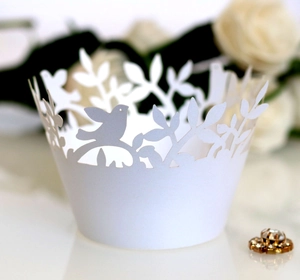 Laser-cut cupcake liner with bird and leaf pattern in white paper for muffin decoration