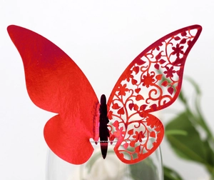 Detail of red laser-cut butterfly cup card with elegant floral hollow patterns for weddings
