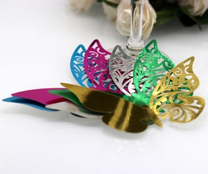 Detail of laser-cut butterfly place cards in five metallic colors for glass decoration